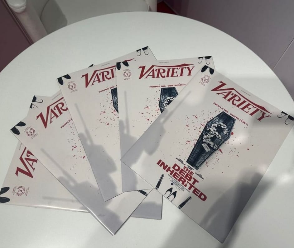 Five printed copies of Variety fanned out on a table, each with The Debt Inherited on the front cover